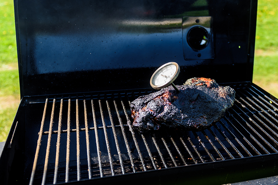 Meat Thermometer Stuck Into Brisket On A Grill